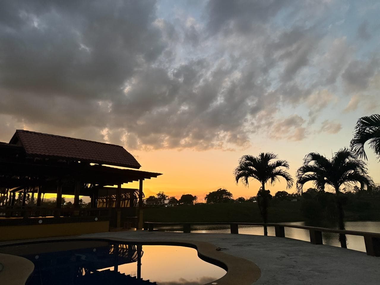 Piscina al atardecer con cielo dramático sobre el lago